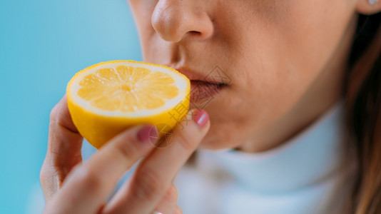 失明或嗅觉臭可能出现一种知19年的症状由冠引起的传染妇女试图感觉到柠檬的味道厌食或嗅觉失明背景图片