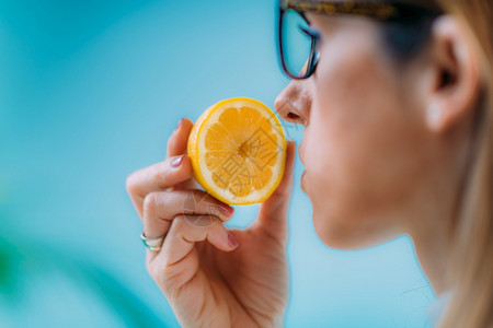 冠状引起的传染妇女试图感觉到柠檬的气味厌食或嗅觉失明去能力背景图片