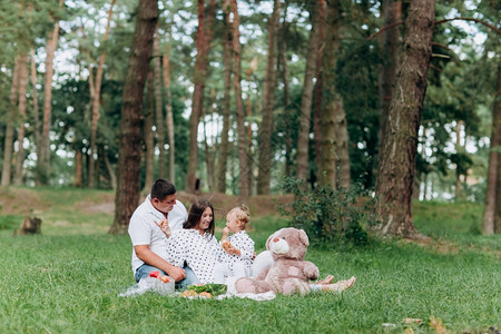 家庭野餐妈爸和女儿坐在公园的毯子上暑假图片