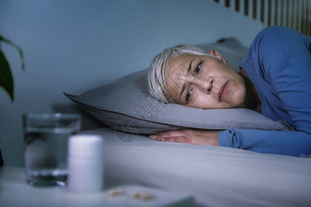 失眠和不起作用的安眠药有睡问题的成年妇女半夜醒来图片