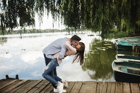 情侣在湖边木桥上弯腰接吻图片