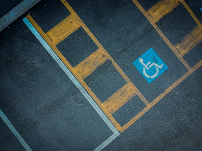 涂在深沥青上的蓝色残疾人停车标志黑色的残疾人空位图片