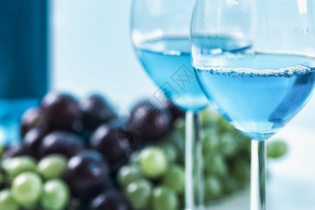 两杯红酒底有蓝葡萄和图片
