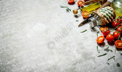背景的西红柿新鲜橄榄油和香料石头背景的西红柿橄榄油和香料图片