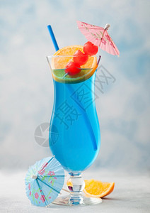蓝色环礁夏季鸡尾酒经典玻璃甜鸡尾酒樱桃橙色切片蓝桌底的雨伞图片