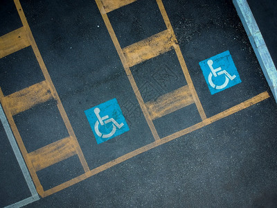 涂在深沥青上的蓝色残疾人停车标志黑色的残疾人空位图片