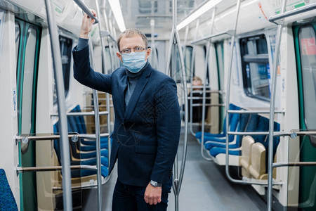 20年的冠状危机男子在空地下工作使用公共交通防护面罩止在隔离期间佩戴保护外科手术面具图片