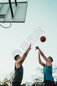 青年篮球运动员在户外法庭上一对地打球体育和篮概念图片