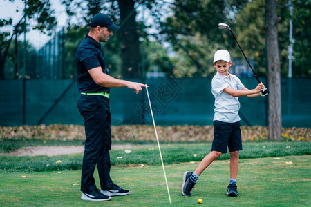 个人训练高尔夫教小男孩打高尔夫图片