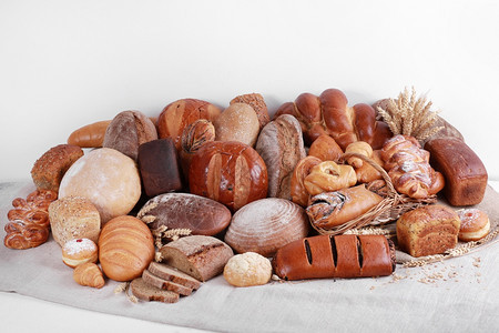 亚麻和白墙背景的不同类型烤面包货物亚麻和白墙背景的不同类型烤面包货物图片