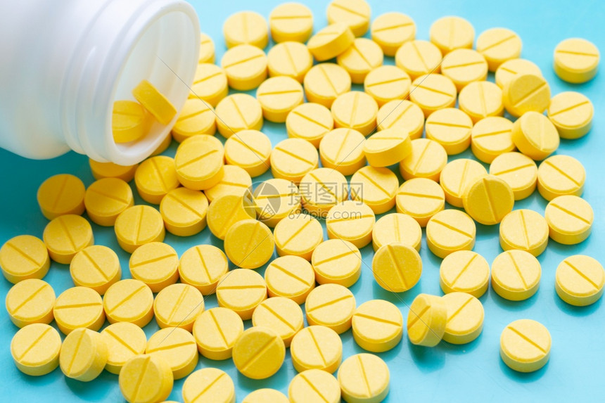 蓝色背景上黄的扑热氨醇药片图片