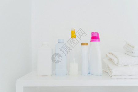 折叠的白毛巾和酒瓶带有白色背景的洗涤剂清和洁概念您文本的空间图片
