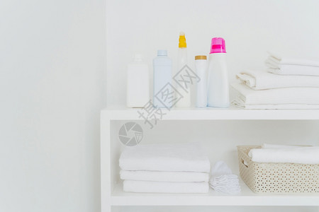 清洁的白色毛巾在控制台上用洗涤剂刷干净的白色毛巾在背景上隔绝在白色背景上图片