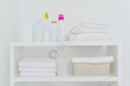 洗衣房有整齐折叠的毛巾洗液或涤剂的瓶子图片