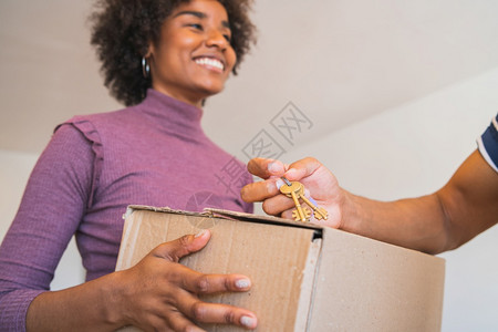 近身的年轻女在家里收回包裹送货航运和邮政服务的概念图片
