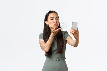 女创业者概念时尚女博客使用过滤器应程序自拍在电话相机上吹吻为社交媒体文章作姿势白背景人小企业所有者女家概念创业者概念女博客使用过图片