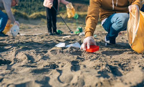 一群志愿者在海滩上捡垃圾高清图片
