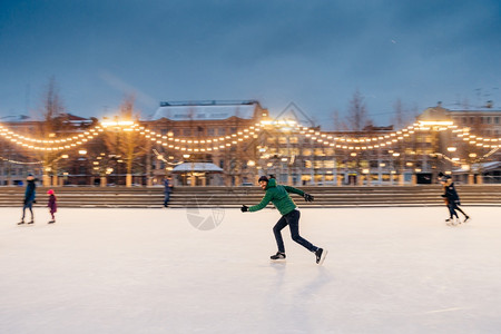参加冬季体育活动的跃运胡子男户外肖像准备在带有花冠的圣诞节冰圈上参加滑比赛图片