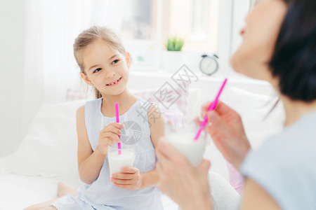 女孩与母亲一起喝着美味的奶昔图片