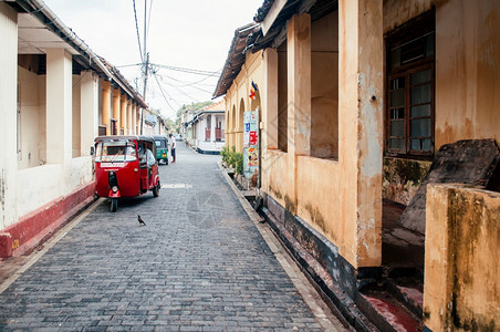 在小巷中的一辆红色三轮摩托车图片