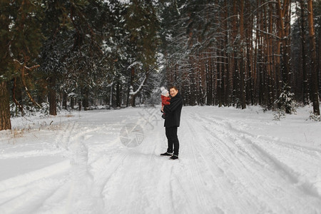 快乐的爸和小儿子在冬季雪林里玩乐的肖像图片