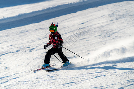 在一个冬季度假胜地的滑雪坡上戴着滑雪头盔和谷歌眼镜的快乐男孩滑雪坡上戴着滑雪头盔和谷歌眼镜的快乐男孩背景图片