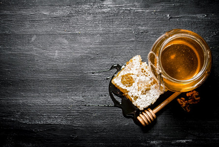 香薰蜡片蜂蜜背景天然梳子和一个玻璃罐放在黑色生锈桌子上蜂蜜背景天然梳子和玻璃罐上背景