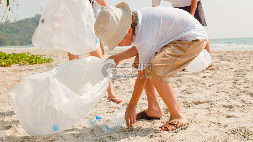 在海滩上收集塑料垃圾的年轻快乐家庭活动asi志愿者帮助保持自然清洁图片