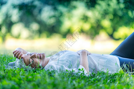 深思熟虑的成女人沉浸在水中躺下感觉与大地和自然相连图片