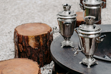 传统茶饮概念三个古老的金属铜蒸汽室外靠近木质树桩生锈的风格图片