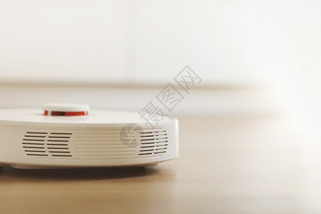 在室内客厅用层地板清洗粉尘的白色机器人吸尘智能电子家用技术智能在室内层地板清洗粉尘的白色机器人吸尘智能家用技术背景图片