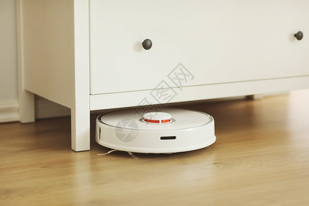 在室内客厅用层地板清洗粉尘的白色机器人吸尘智能电子家用技术智能在室内层地板清洗粉尘的白色机器人吸尘智能家用技术背景