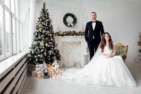 圣诞婚纱新婚夫妻坐在圣诞树旁拍婚纱照背景
