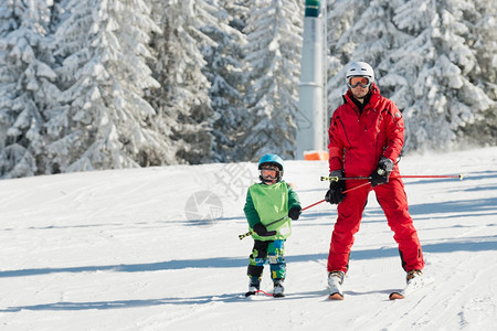 滑雪教练和小男孩在山上上课图片