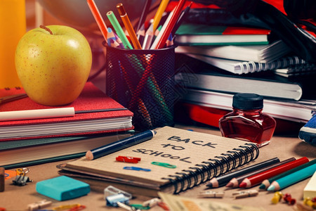 回收纸笔记本彩色铅绿苹果书籍包红墨水磨刀和蓝色橡皮纸回到学校概念图片