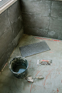 在玻璃化梯田地板上铺瓷砖的工作图片