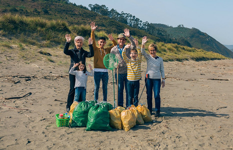 一群在清理海滩后装满垃圾袋的志愿者在清理海滩后装满垃圾袋图片
