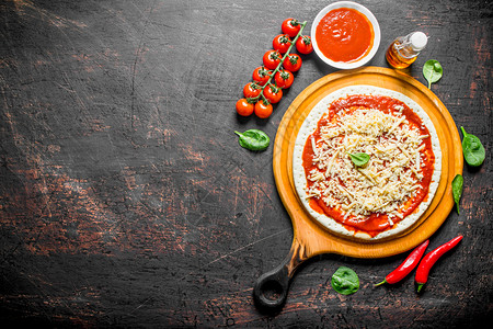 生披萨推出自制的面粉以黑暗生锈背景图片