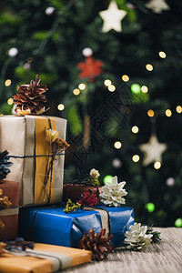 圣诞礼物包装在彩色品纸上圣诞树背景灯光亮度不高圣诞礼物图片