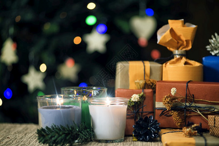 圣诞礼物装在手工制作的盒子和装饰圣诞树上背景有彩色的灯光没有焦点图片