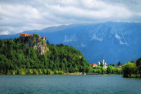 美丽的中世纪城堡在流淌着冰河的湖上与背景中的山峰图片