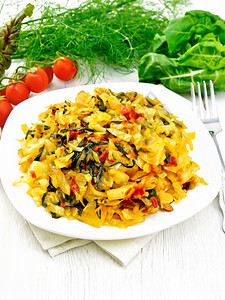 餐巾纸面食和木板底叉的白上用叶菜和西红柿做白炖面食和木板底叉子图片
