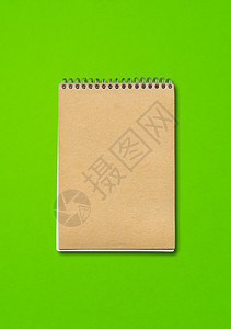 关闭的笔记本模型棕色纸封面隔离在绿色背景上绿色背景上的螺旋关闭笔记本模型图片