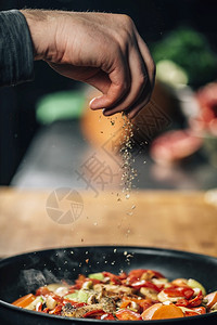 厨师在锅里对蔬菜喷洒杂食运动模糊调料厨师对蔬菜喷洒杂食图片