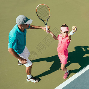 网球训练中与年轻女孩一起参加网球训练的教官图片