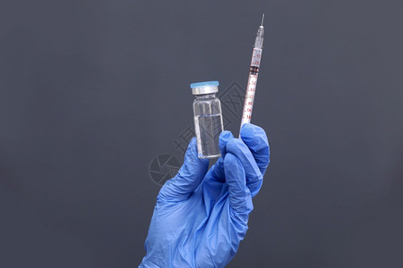 医生、护士或科学家手持蓝硝基套,持流感、麻疹为疾病爆发接种疫苗注射的冠状病毒疫苗、药品和物概念。 医生、护士或科学家手持蓝色硝基图片