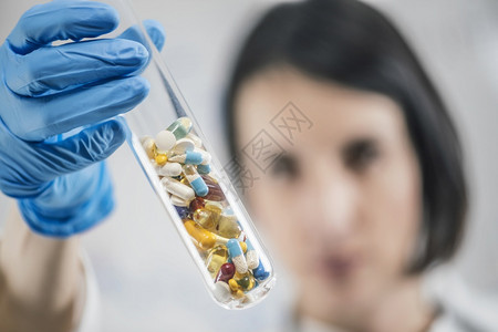 医生的手持实验室玻璃试管装满了多彩药丸物玻璃试管装满了多彩药丸图片