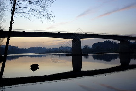 河下日落桥一艘船日落背景图片