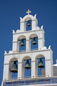 白色教堂在希腊群岛桑托里尼上的白钟塔背景