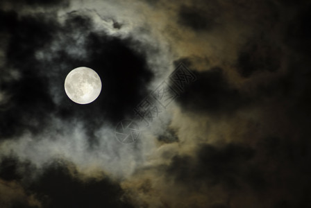 在黑暗的夜中在云上飘扬大月亮图片